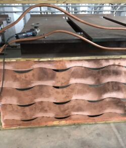 Rusty, worn metal drawers with a wavy design in an industrial setting.