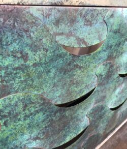 Close-up of a textured metal surface with curved cutouts.