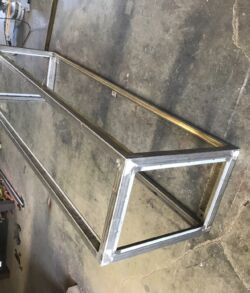 A rectangular metal frame structure on a concrete floor.