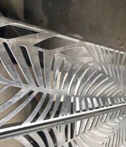 Metal sculpture with intricate leaf-like cutouts.
