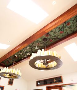 Floral Angel Trumpet ceiling sculpture Ceiling light fixtures with decorative wooden beams in a warmly lit room.