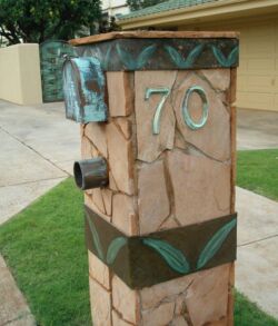 Stone pillar with house number 70 in a residential area.