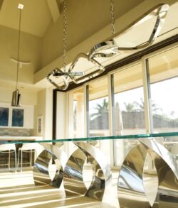 Stainless steel kitchen table and handing lights Modern dining room with unique metallic table and bright natural light.