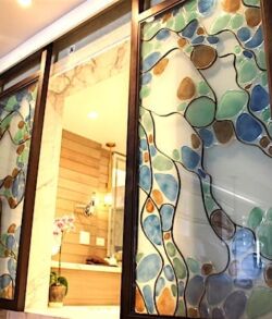 Decorative glass doors with colorful leaf patterns at an entrance.