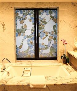 Luxurious bathroom with a large bathtub and decorative window.