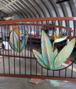 Decorative gate with colorful leaf designs in a workshop.
