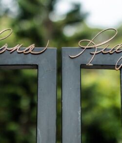Close-up of a metal gate with cursive names.