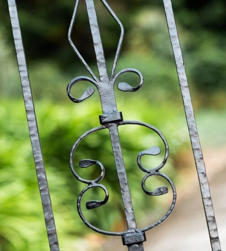 Close-up of an ornate metal gate with decorative scrollwork.