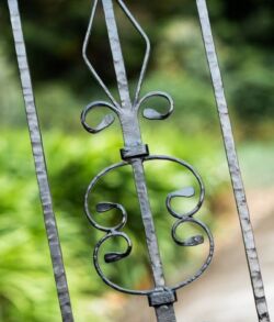 Close-up of an ornate metal gate with decorative scrollwork.