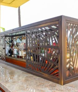 Decorative metal enclosure with intricate patterns around a bar counter.