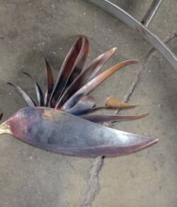 A metal sculpture resembling a bird with spread feathers.