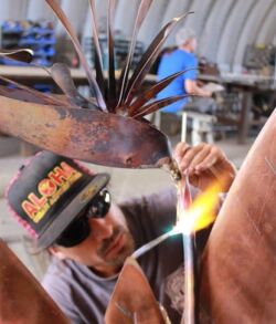 A man welding metal with sparks flying.
