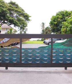 Colorful wave-patterned glass panels on a balcony railing with trees in the background.