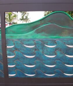 Close up of Copper Mountains with green patina finish. Decorative glass panel with wave and fish designs.
