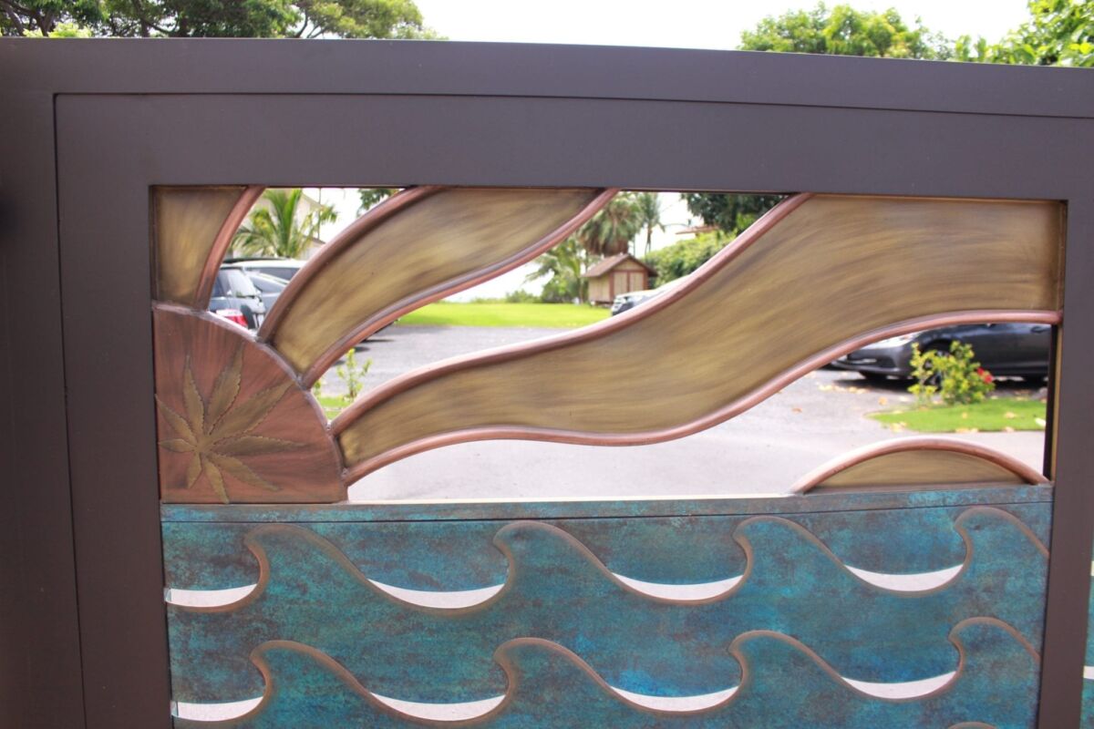 Decorative metal panel with sun and wave designs.