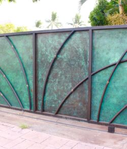 #17 Decorative green-tinted glass fence with artistic black metal curves.
