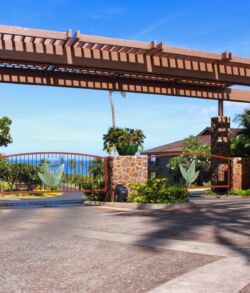 Full front view Entrance gate to a residential community with clear blue sky.