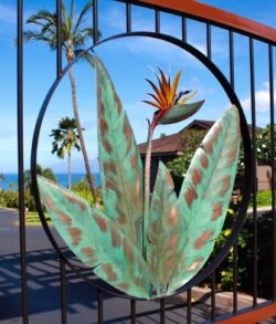 Decorative metal art of a bird of paradise flower on a gate.