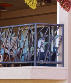 Close up of bamboo rail People seated behind a balcony railing inside a building.
