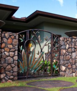 Full view of Zen garden man gate. Decorative metal gate with stone pillars at a modern home entrance.