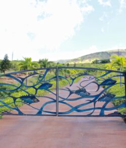 Full view front entrance Decorative wrought iron gate with artistic leaf and branch design.