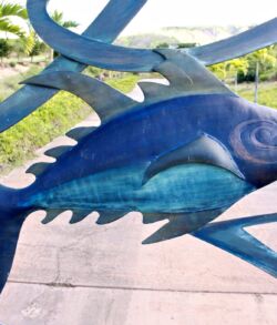 A vibrant blue fish sculpture displayed outdoors.