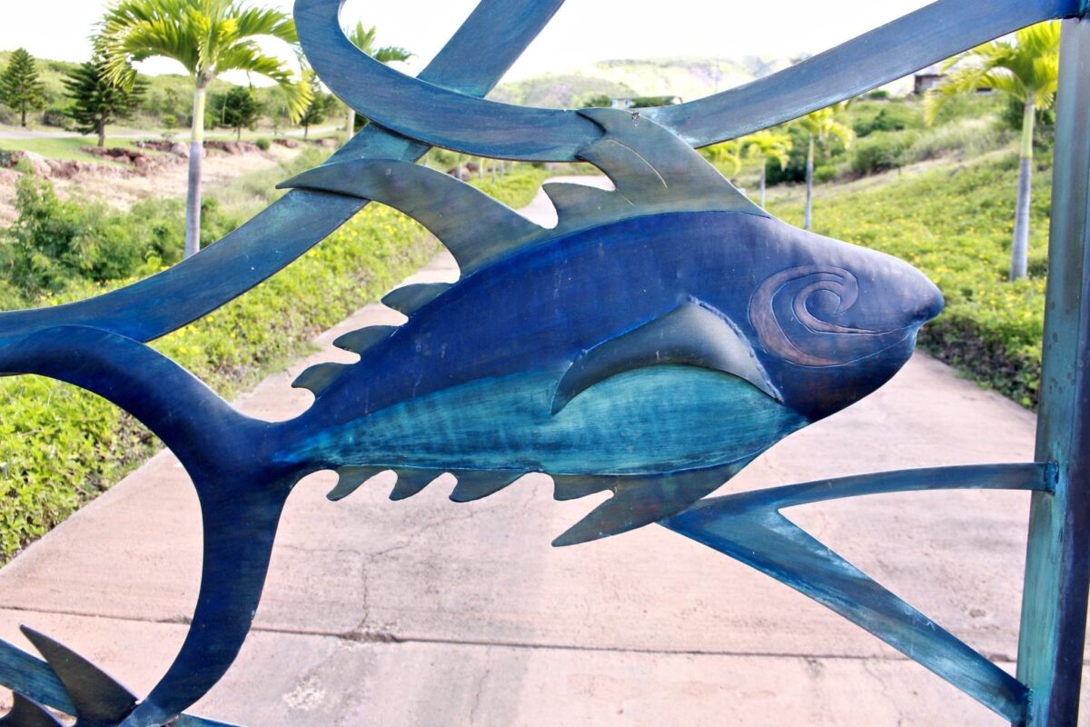 A vibrant blue fish sculpture displayed outdoors.