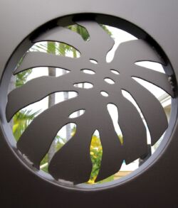 Circular window with a decorative monstera leaf cutout.