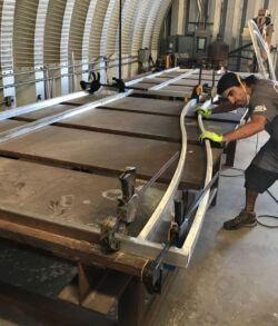 Worker operating heavy machinery in an industrial workshop.