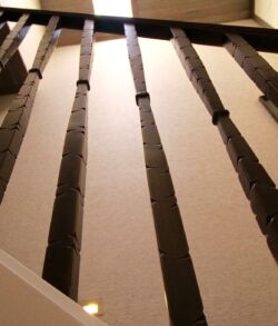 Close-up of a ceiling with exposed wooden beams casting shadows.