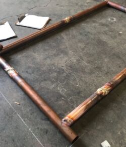 Wooden frame with joint reinforcements on a workshop floor.