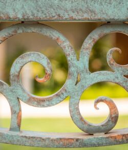 Close-up of an ornate rusty metal scrollwork with blurred background.