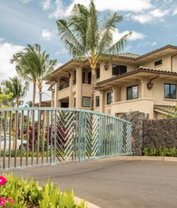 Luxurious tropical house with palm trees and gated entrance.