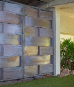A wooden door with a rustic finish next to a garden area.