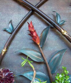 Close-up of a red flower with green leaves and gardening tools.