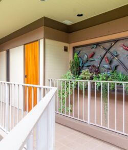 Modern balcony with a vibrant mural and wooden door.