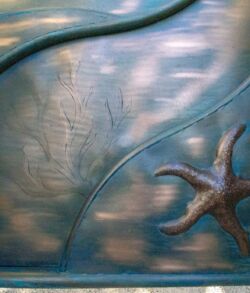 A close-up of a decorative blue metal panel with a starfish design.