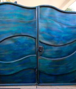 Blue metal gate with wave-like patterns and a central lock.