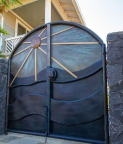 Decorative metal gate with sunburst design and curved panels.