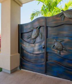Decorative metal gates with bird designs in a residential setting.