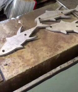 Wooden shark-shaped cutouts on a workbench.