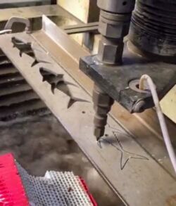 A machine cutting a pattern into a piece of wood.