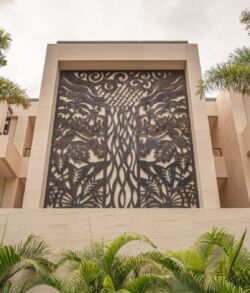 Intricate metal tree artwork on a building facade.