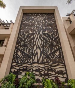 Intricate metal gate with tree design in building entrance.
