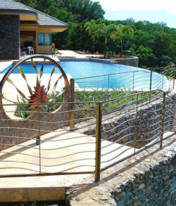 Scenic pool area with a unique circular metal gate and stone walls.