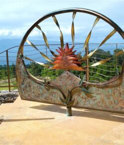 Copper and Brass swivel man gate Artistic metal gate with a sun motif and intricate designs.