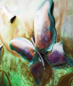 A metallic butterfly with a greenish background.