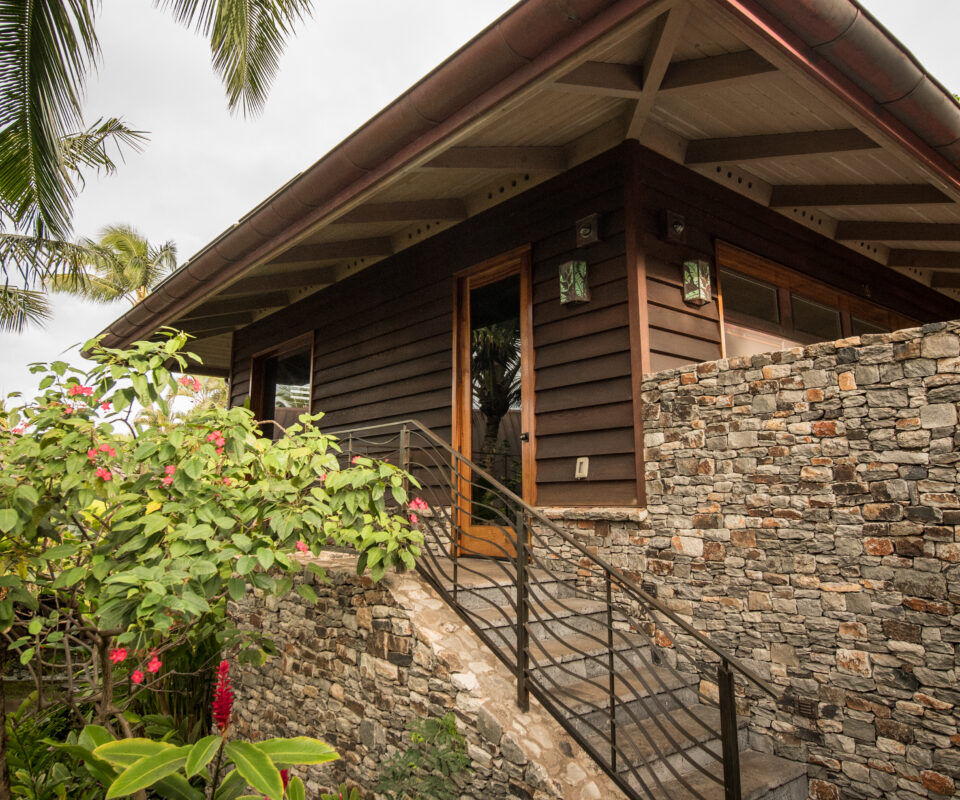 Tropical stone staircase leading to wooden bungalow