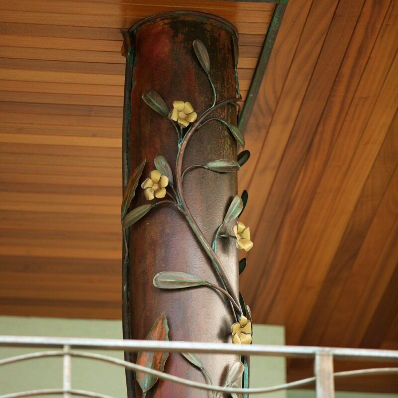 Decorative wooden pillar with carved flowers and leaves.