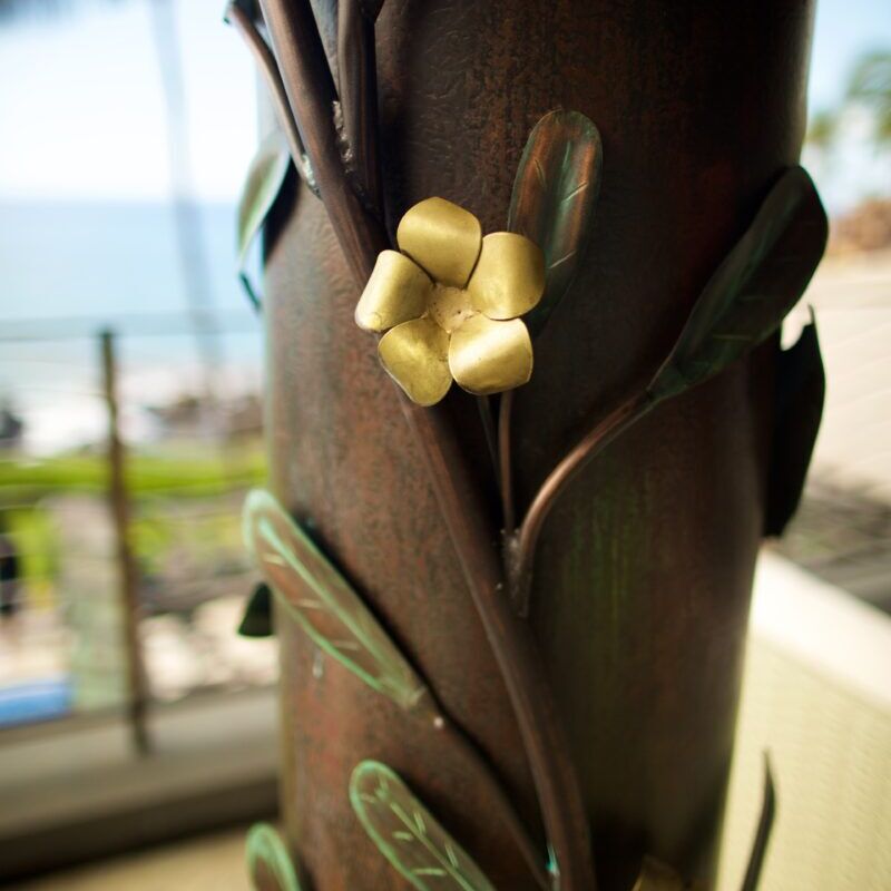 Close-up of a decorative brown vase with a small golden flower detail.